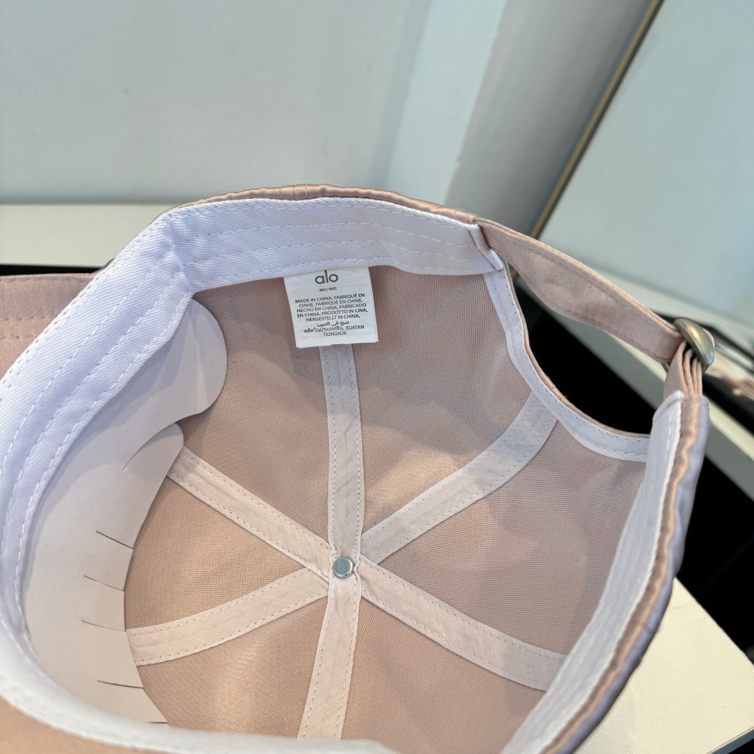 Dusty pink satin baseball cap with a curved brim, featuring a minimalist adjustable back strap.
