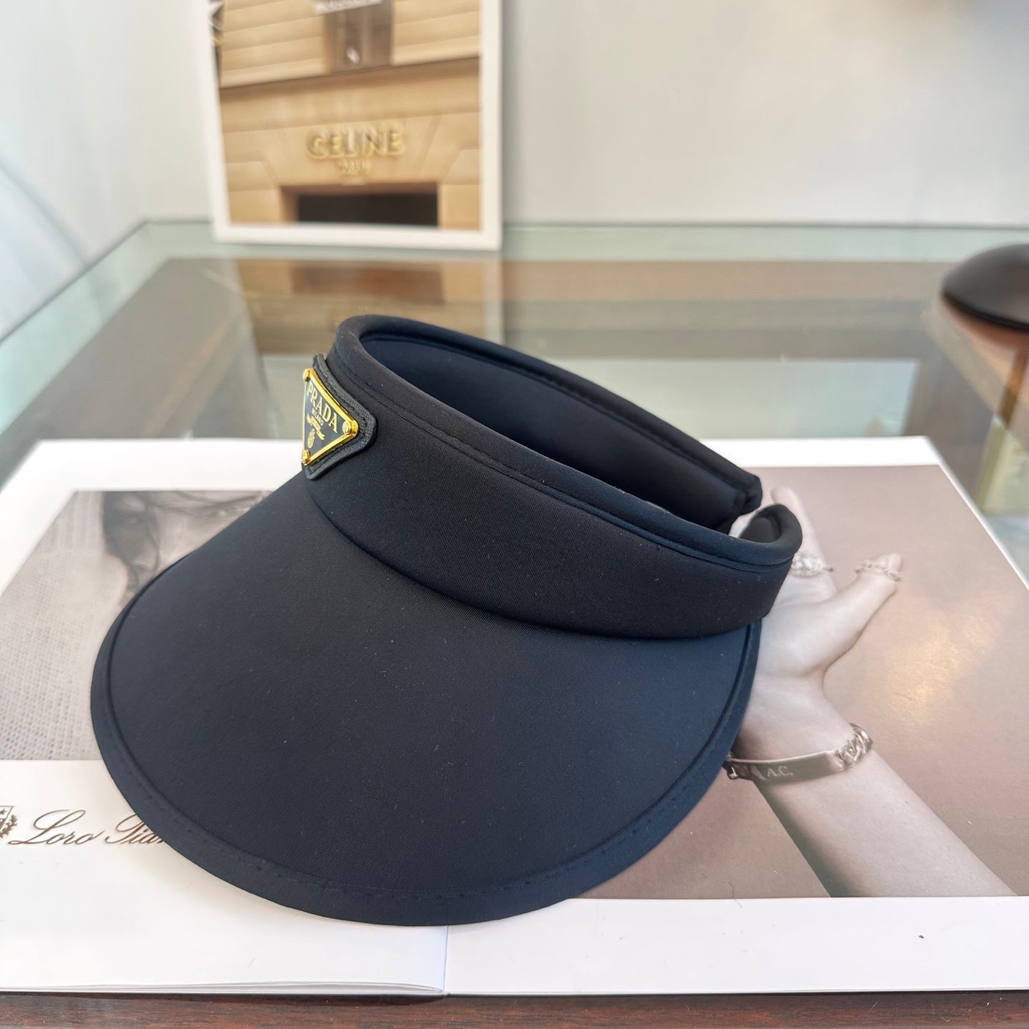 A sleek black wide-brim sun visor featuring a gold triangular emblem, designed for sun protection.