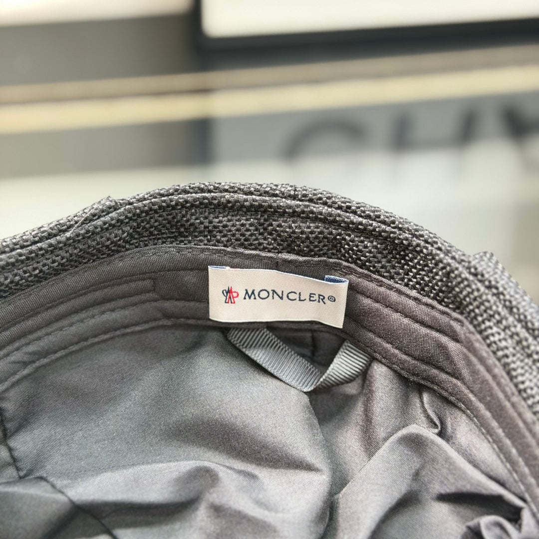 Close-up of a premium dark grey textured ivy cap with a white embroidered logo, high-quality fabric.