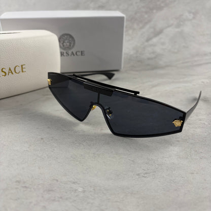 Modern shield sunglasses with a sleek black frame and dark tinted lenses on a grey background.