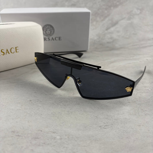 Modern shield sunglasses with a sleek black frame and dark tinted lenses on a grey background.