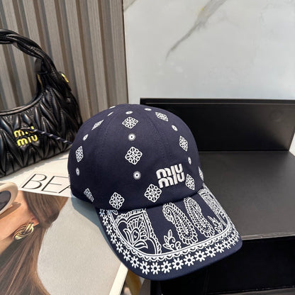 Navy blue baseball cap with white embroidered paisley patterns and an adjustable back strap.
