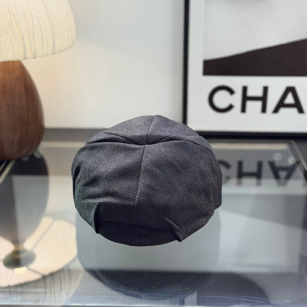 Close-up of a premium dark grey textured ivy cap with a white embroidered logo, high-quality fabric.