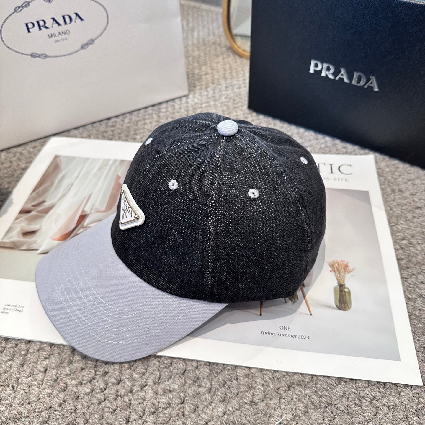 A two-tone denim baseball cap featuring a white triangle emblem patch on the front, neutral brim.