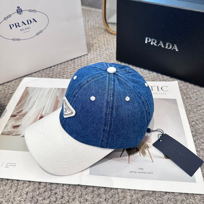 A stylish blue denim baseball cap with a white brim and a triangular metal-look logo patch.
