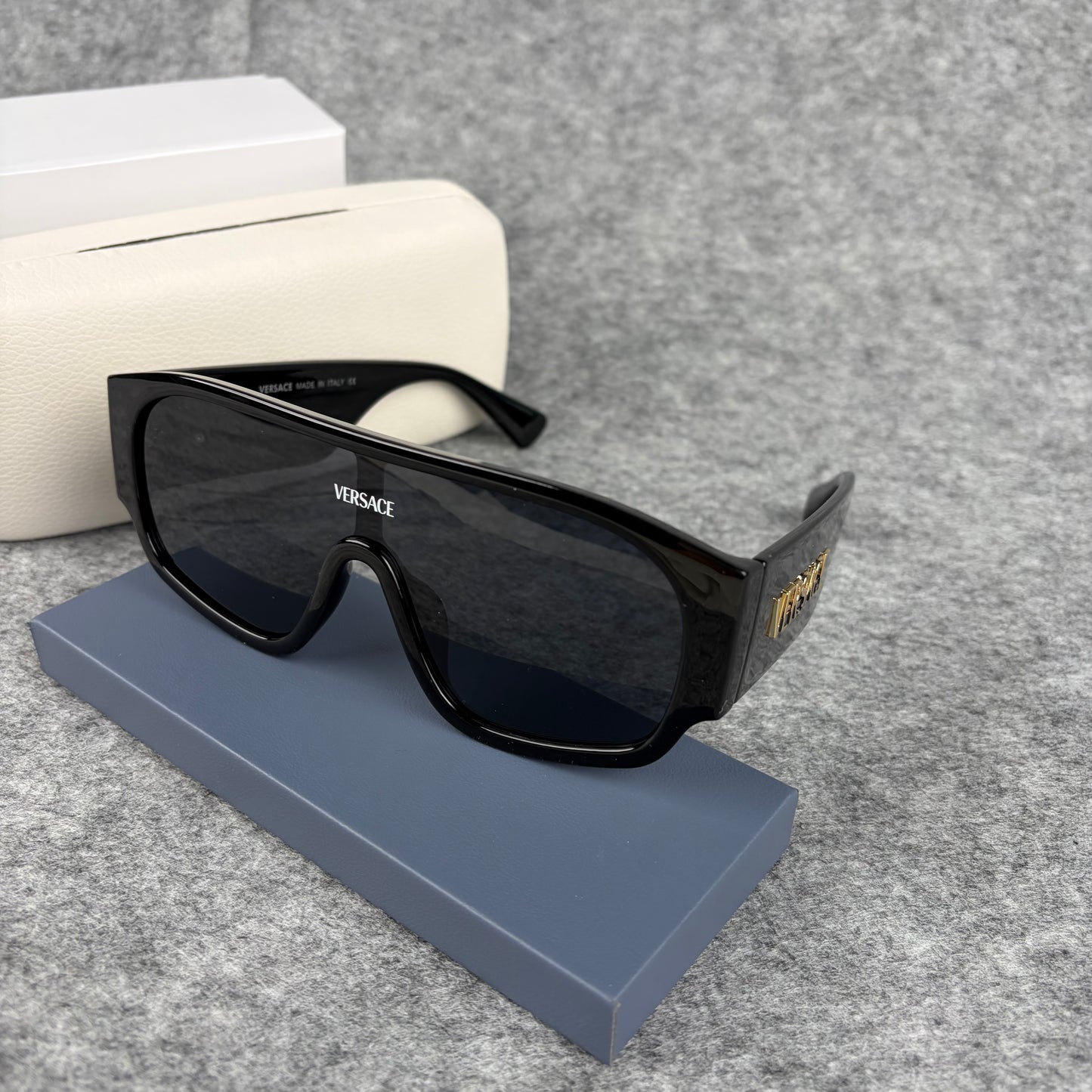 Oversized black shield sunglasses with a clean, modern aesthetic and protective hard storage case.