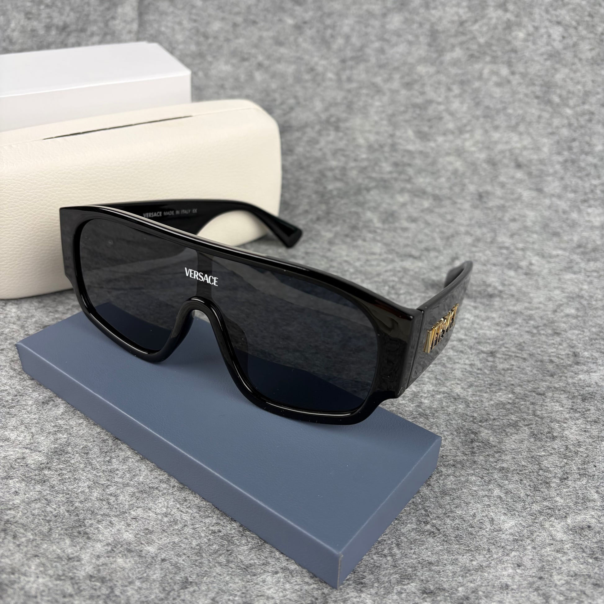 Oversized black shield sunglasses with a clean, modern aesthetic and protective hard storage case.