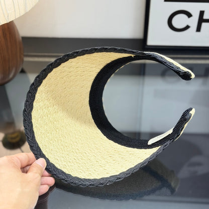 Woven straw sun visor with black contrast trim and decorative logo detail for summer protection.