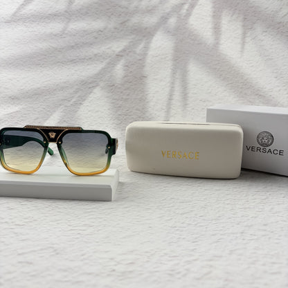 Oversized geometric sunglasses with green-to-yellow gradient lenses and gold metallic frame details.