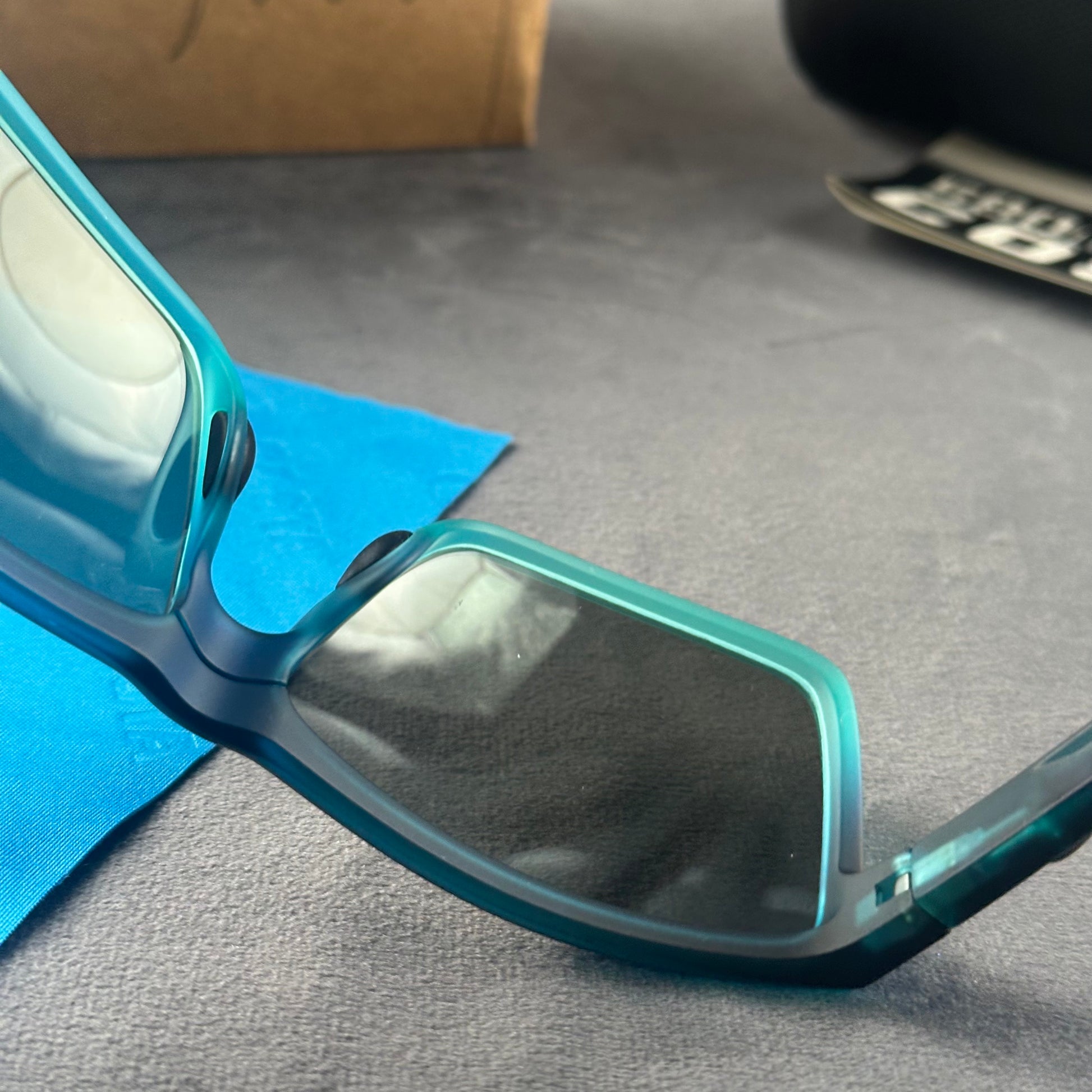 Blue and teal gradient frame sport sunglasses with polarized lenses resting on a blue cloth.