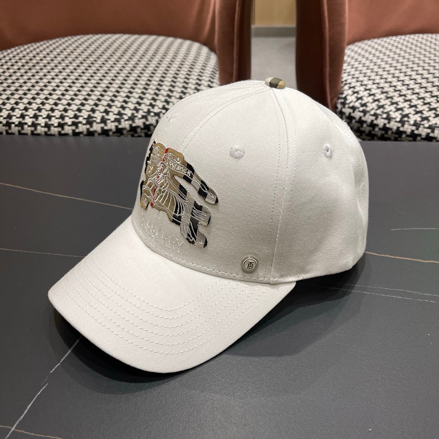 A white structured cotton baseball cap featuring an intricate equestrian embroidery patch on front.