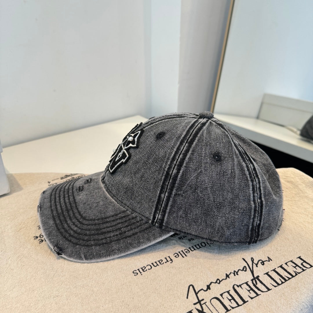 Distressed charcoal denim baseball cap with an embroidered LOVE patch featuring flower accents.
