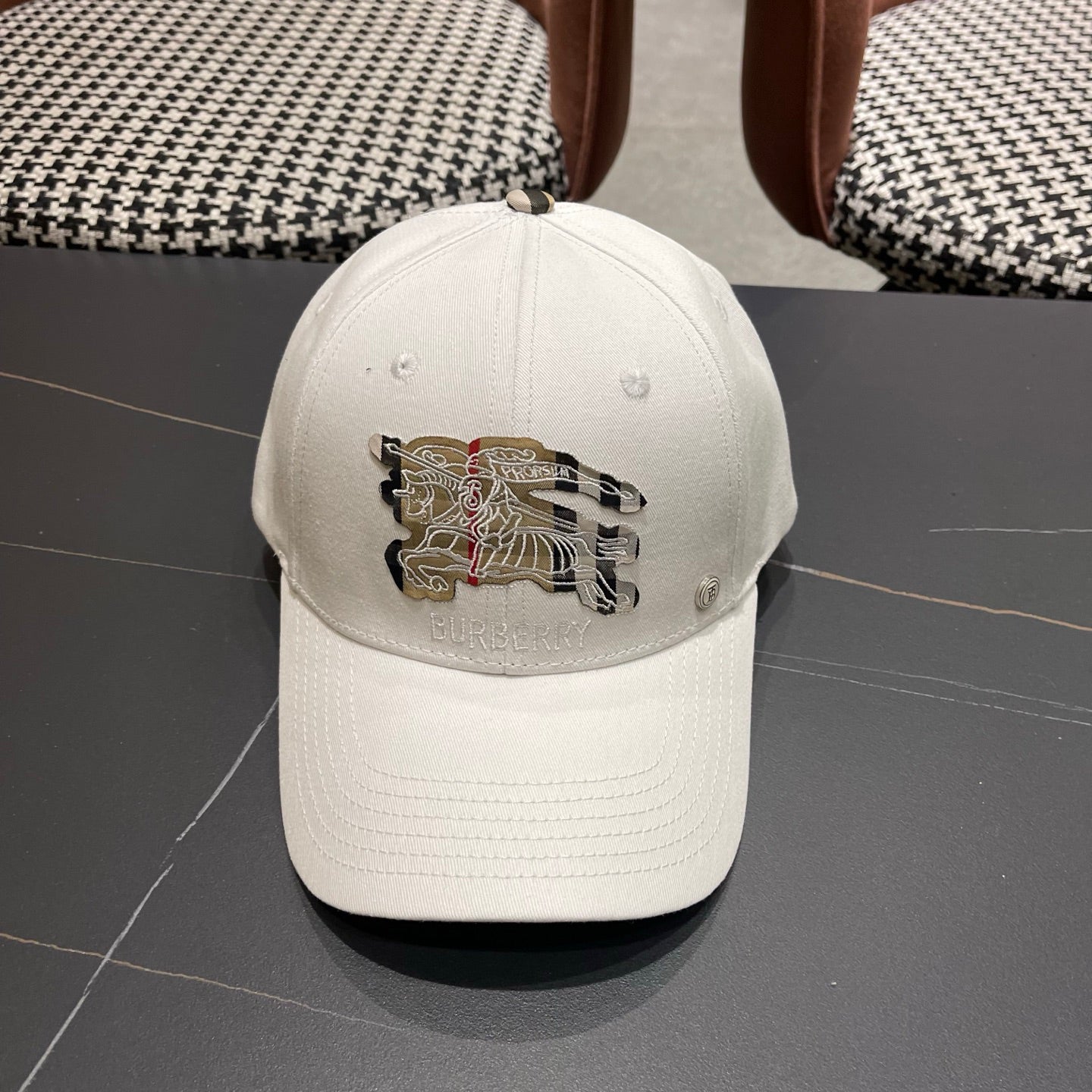 A white structured cotton baseball cap featuring an intricate equestrian embroidery patch on front.