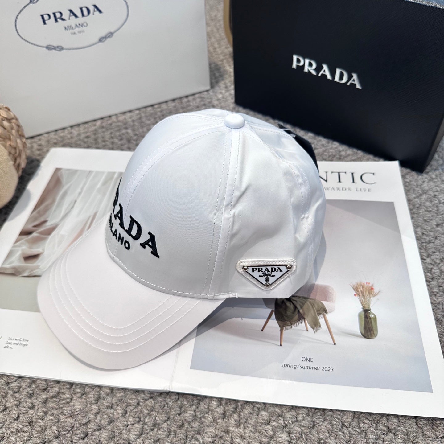 A clean white baseball cap featuring black embroidered lettering, structured crown, and curved visor