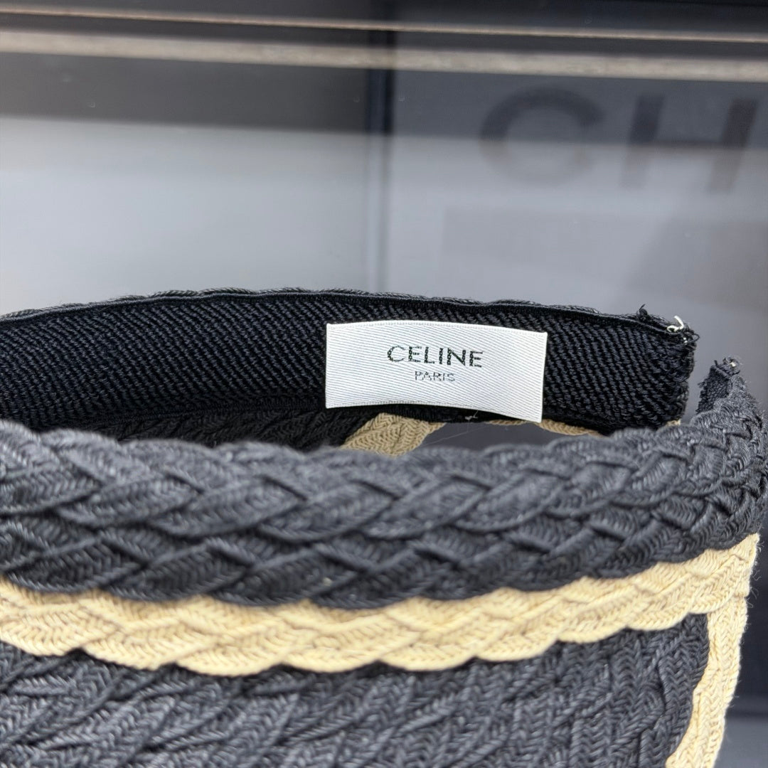 Close-up of a stylish woven straw sun visor with contrast border and white emblem detail.