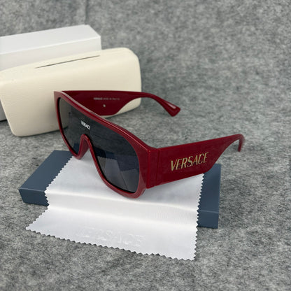 Oversized bold red shield sunglasses with dark lenses on a grey background with a white case.