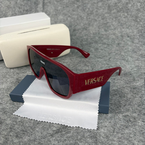 Oversized bold red shield sunglasses with dark lenses on a grey background with a white case.