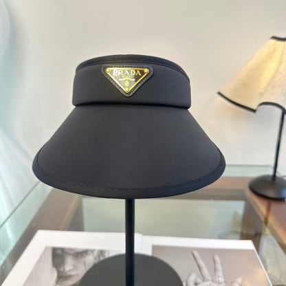 A sleek black wide-brim sun visor featuring a gold triangular emblem, designed for sun protection.