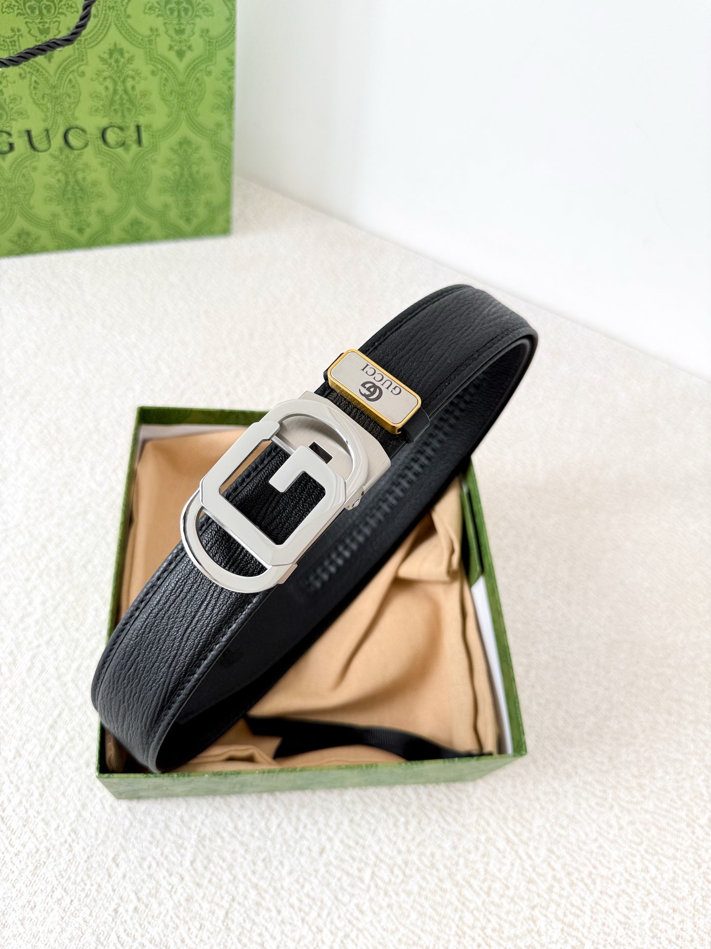 Premium black leather belt with a modern silver automatic steel buckle and detailed grain texture.