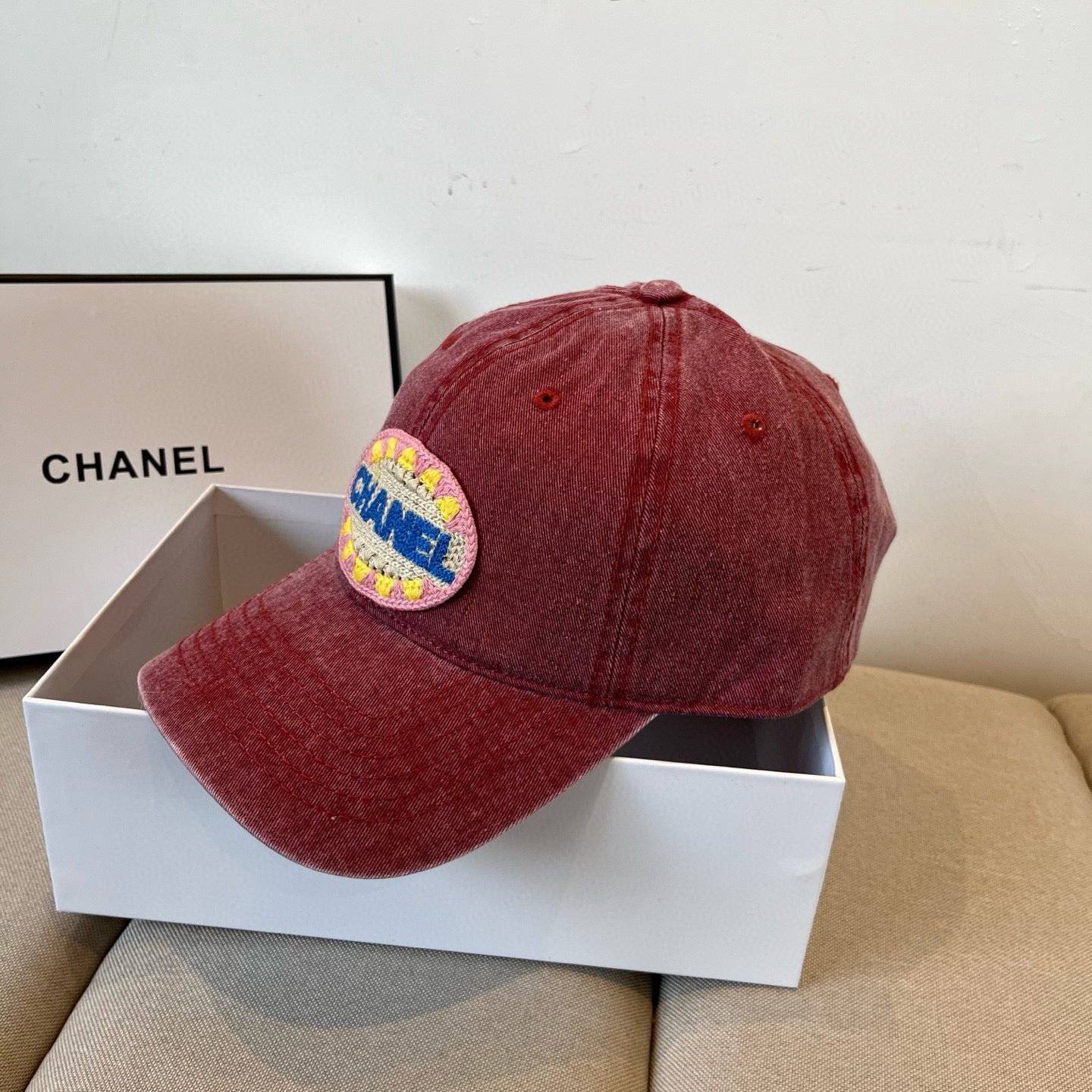 Red distressed cotton baseball cap featuring a colorful embroidered circular graphic patch.