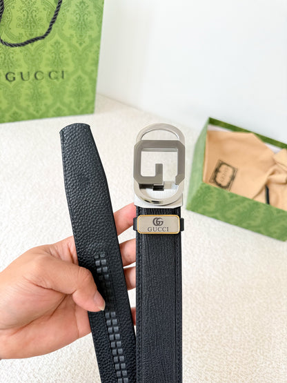 Black textured genuine leather belt with a modern metallic geometric buckle on a white surface.