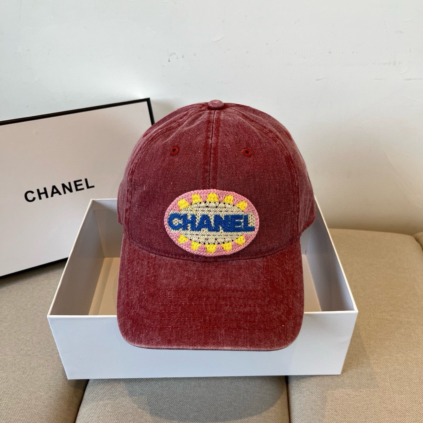 Red distressed cotton baseball cap featuring a colorful embroidered circular graphic patch.