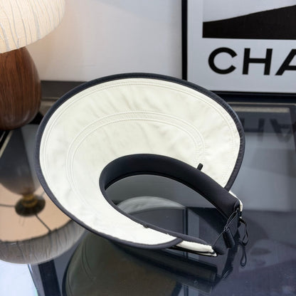 A stylish off-white open-top sports visor with black trim and embroidered text detailing.