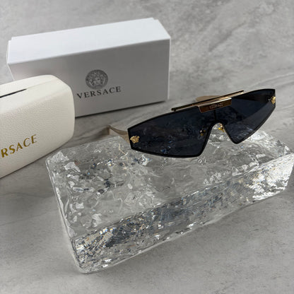 Gold metal frame shield sunglasses with dark lenses, featuring elegant temple detailing.
