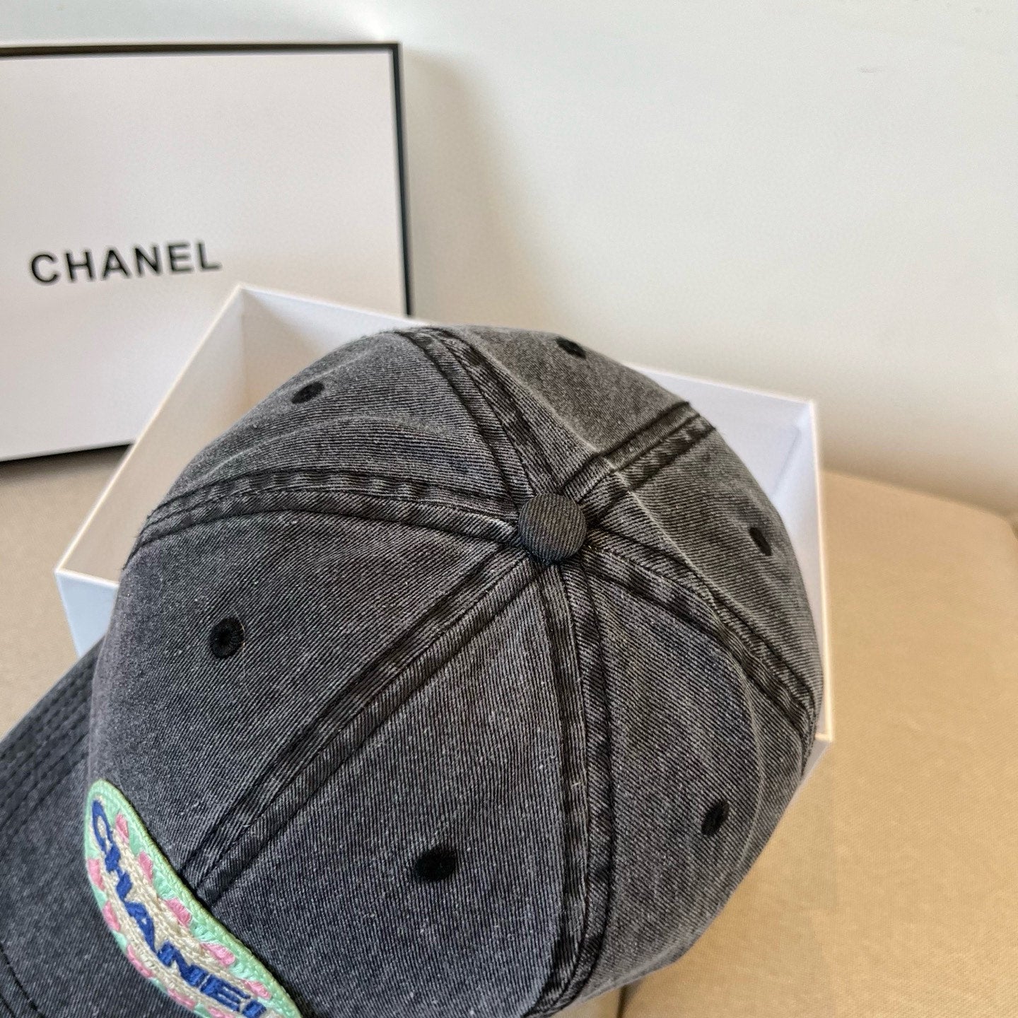 Black vintage-washed denim baseball cap featuring a colorful embroidered circular front patch.