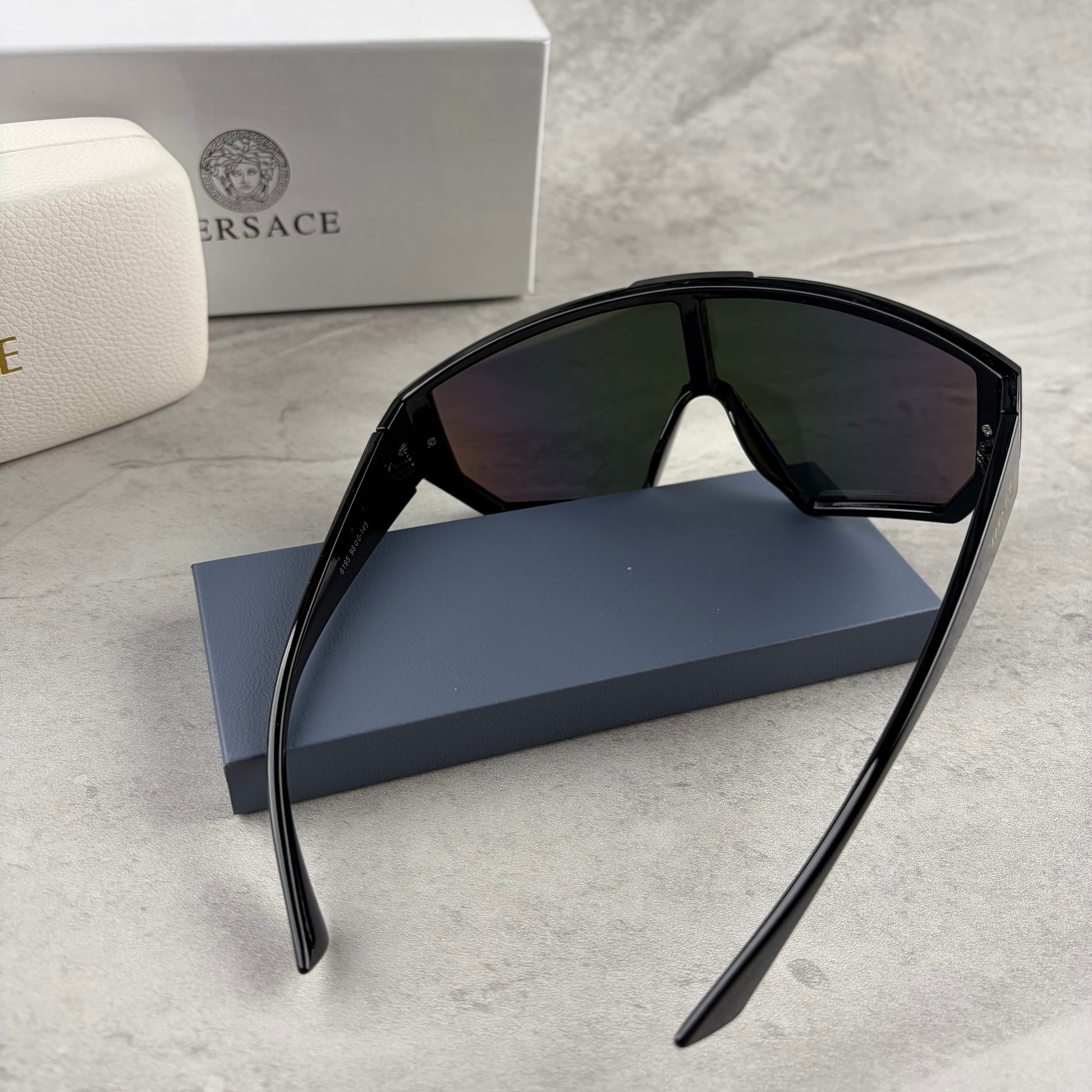 Modern shield-style visor sunglasses with wide black frames and vibrant gradient mirror lenses.