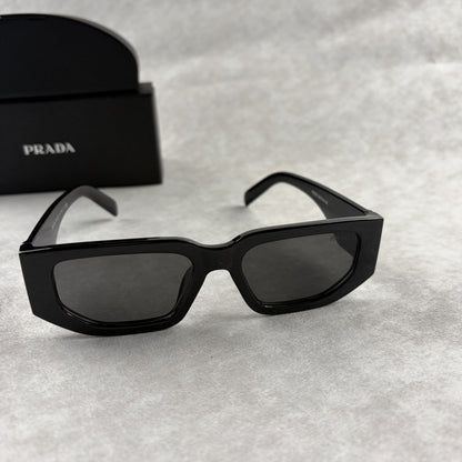 Modern black rectangular sunglasses with dark lenses and thick frame, isolated on a light background