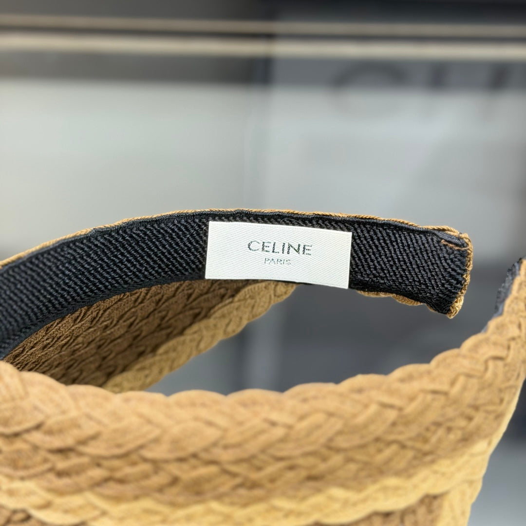 A stylish, high-quality woven straw visor hat with a decorative emblem, perfect for summer sun prote