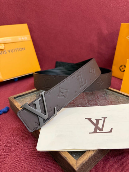 Close-up of a brown embossed leather belt featuring a matte metal buckle and patterned surface.