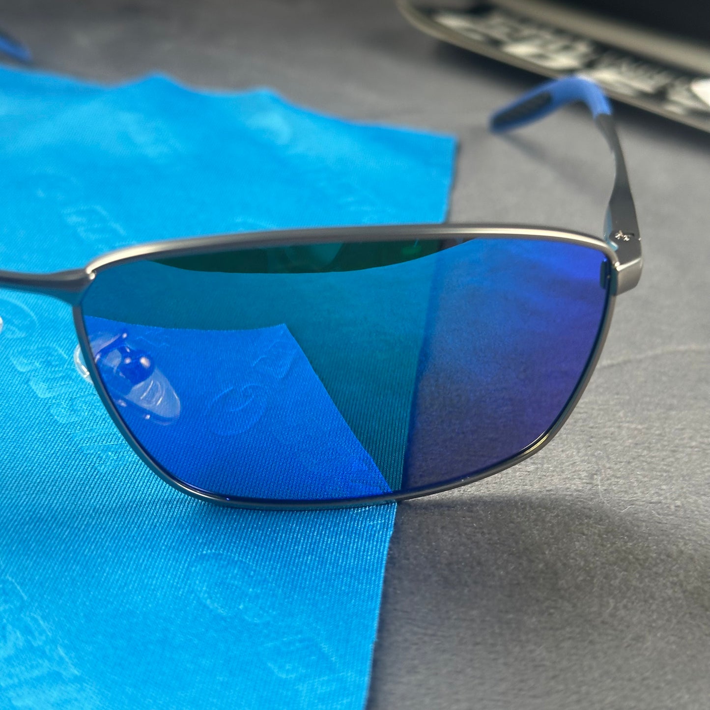Close-up of performance polarized sunglasses with blue mirror lenses and lightweight metal frame.