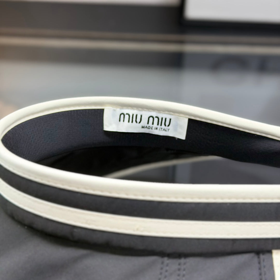 A black sun visor with white contrast trim, featuring an open-top design for breathability and sun p