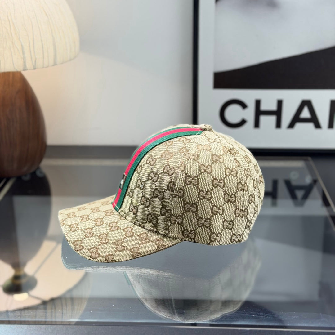 A beige monogram pattern baseball cap with a green and red central stripe and adjustable leather str