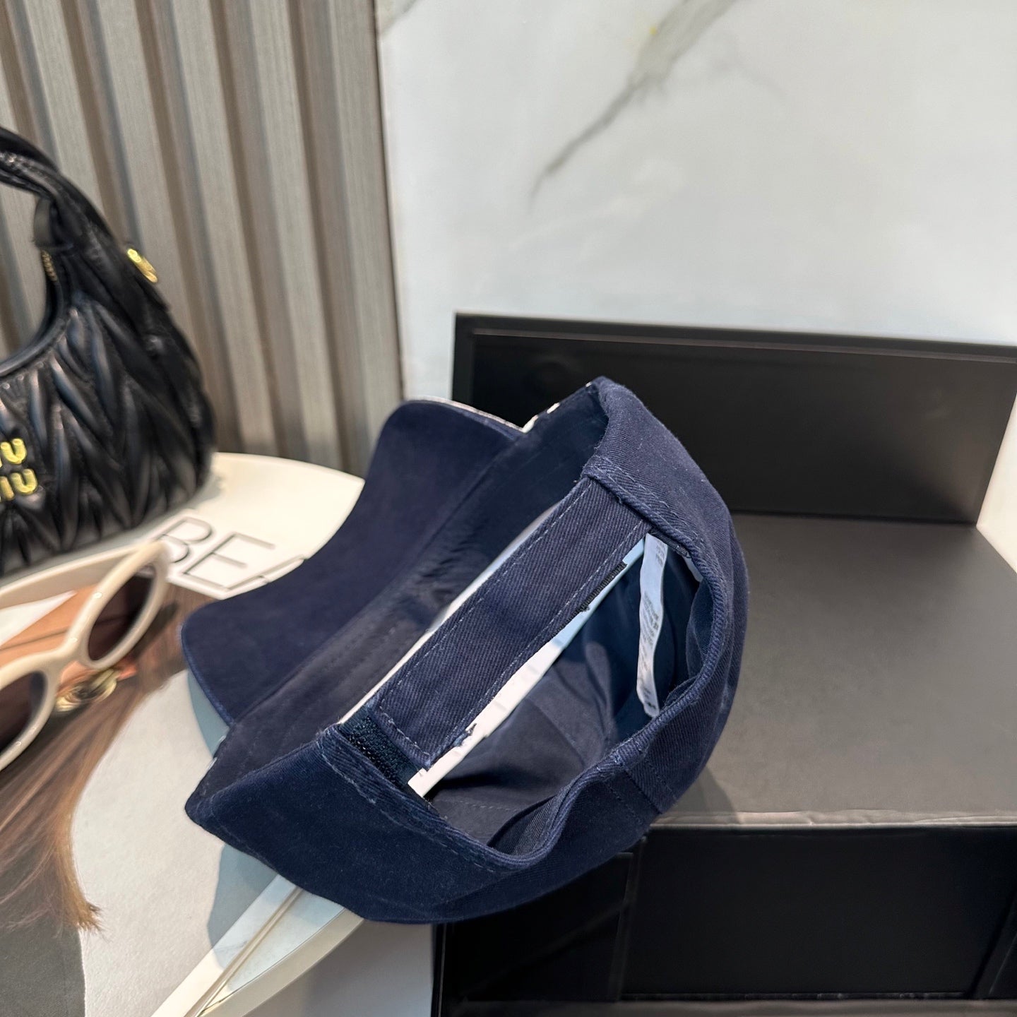 A navy blue cotton baseball cap with white embroidered logo and stripe detail on the side.