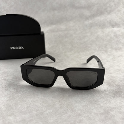 Modern black rectangular sunglasses with dark lenses and thick frame, isolated on a light background