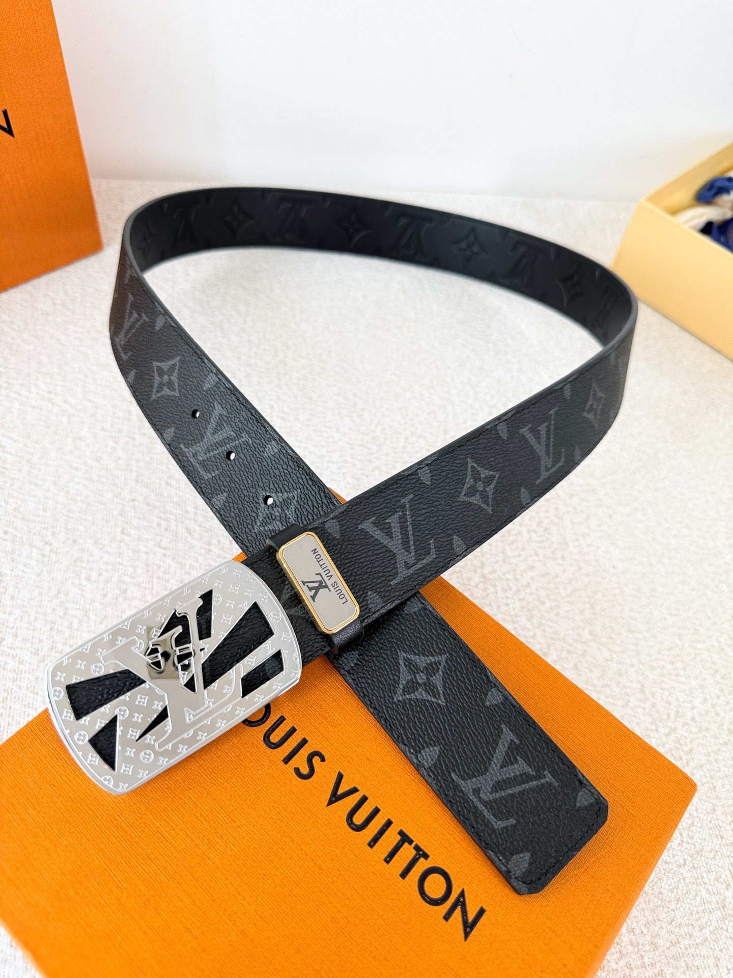 A black leather belt with monogram pattern and an intricate silver-tone buckle, 3.8cm wide.