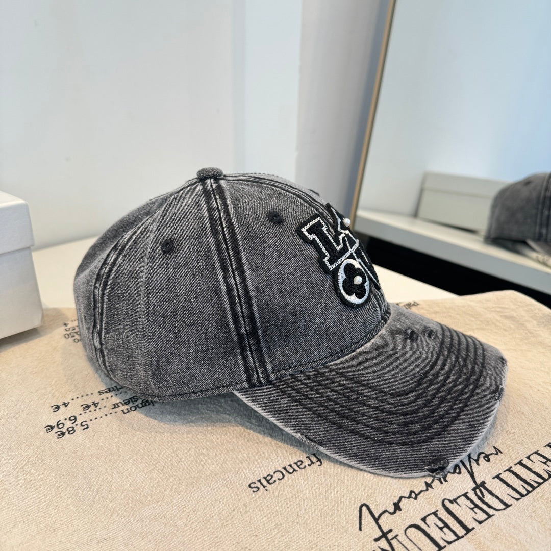 Distressed charcoal denim baseball cap with an embroidered LOVE patch featuring flower accents.