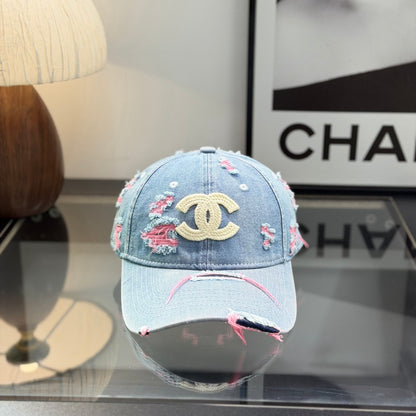 Distressed light wash denim baseball cap with frayed pink stitching and embroidery on the front.