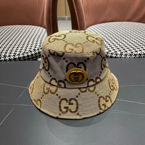 A beige canvas bucket hat with an all-over brown monogram pattern and a decorative gold-toned emblem