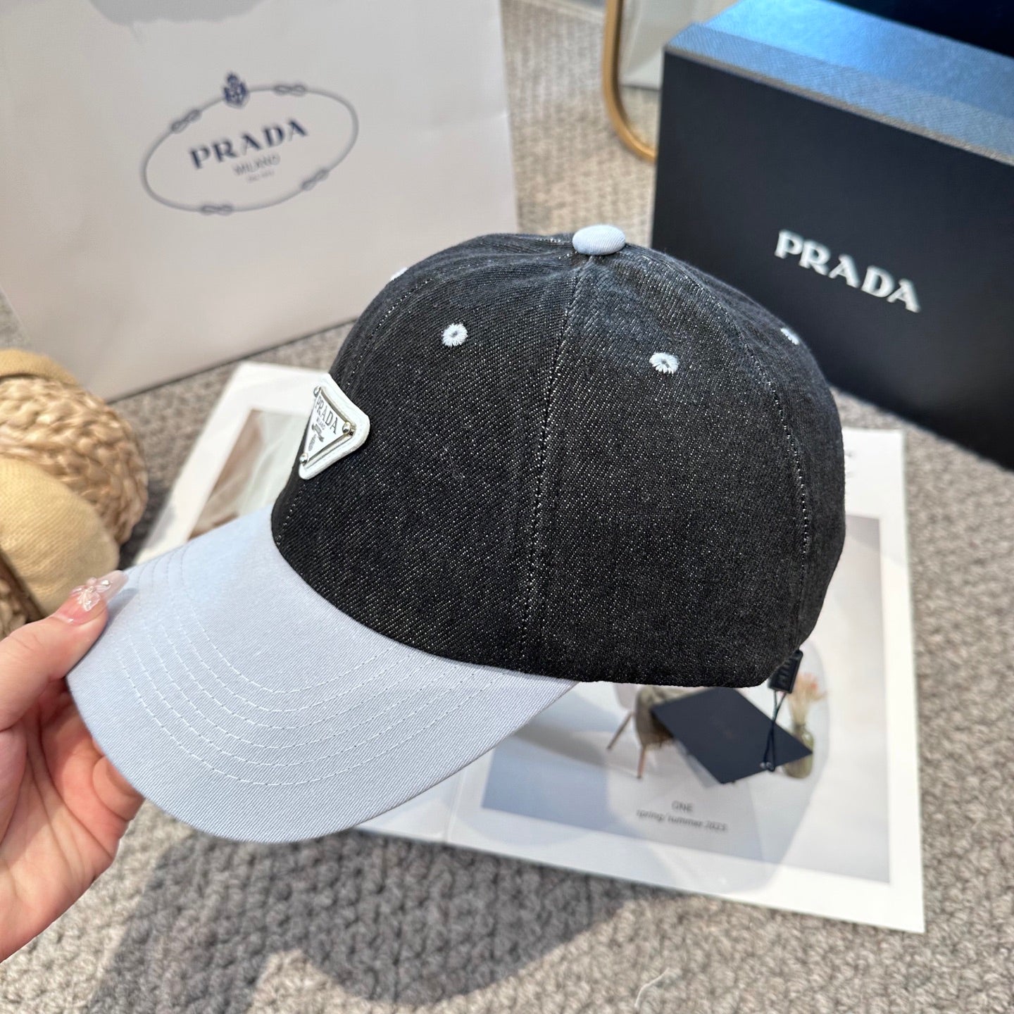A two-tone denim baseball cap featuring a white triangle emblem patch on the front, neutral brim.