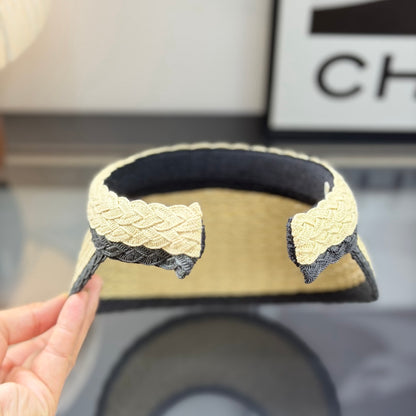 Woven straw sun visor with black contrast trim and decorative logo detail for summer protection.