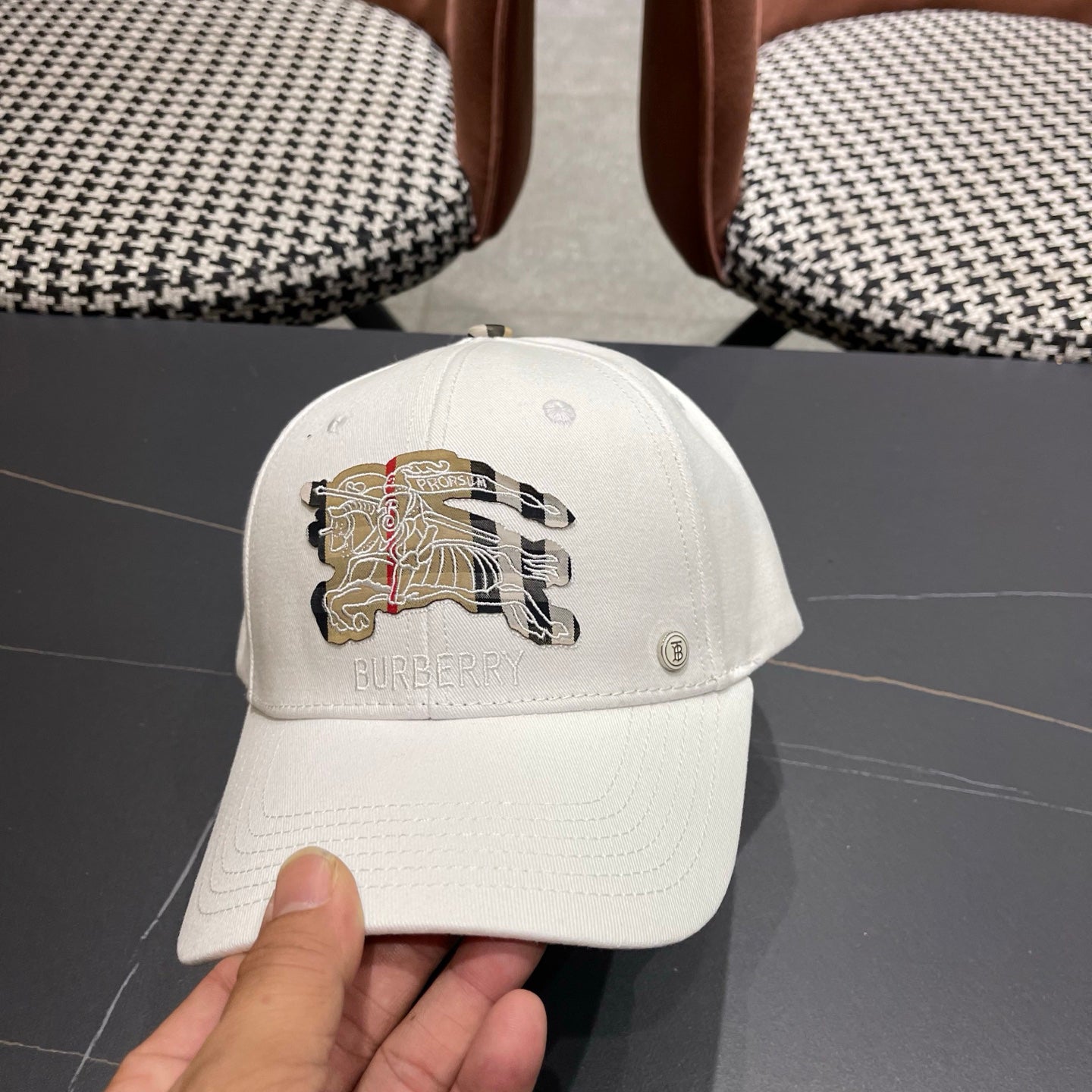 A white structured cotton baseball cap featuring an intricate equestrian embroidery patch on front.