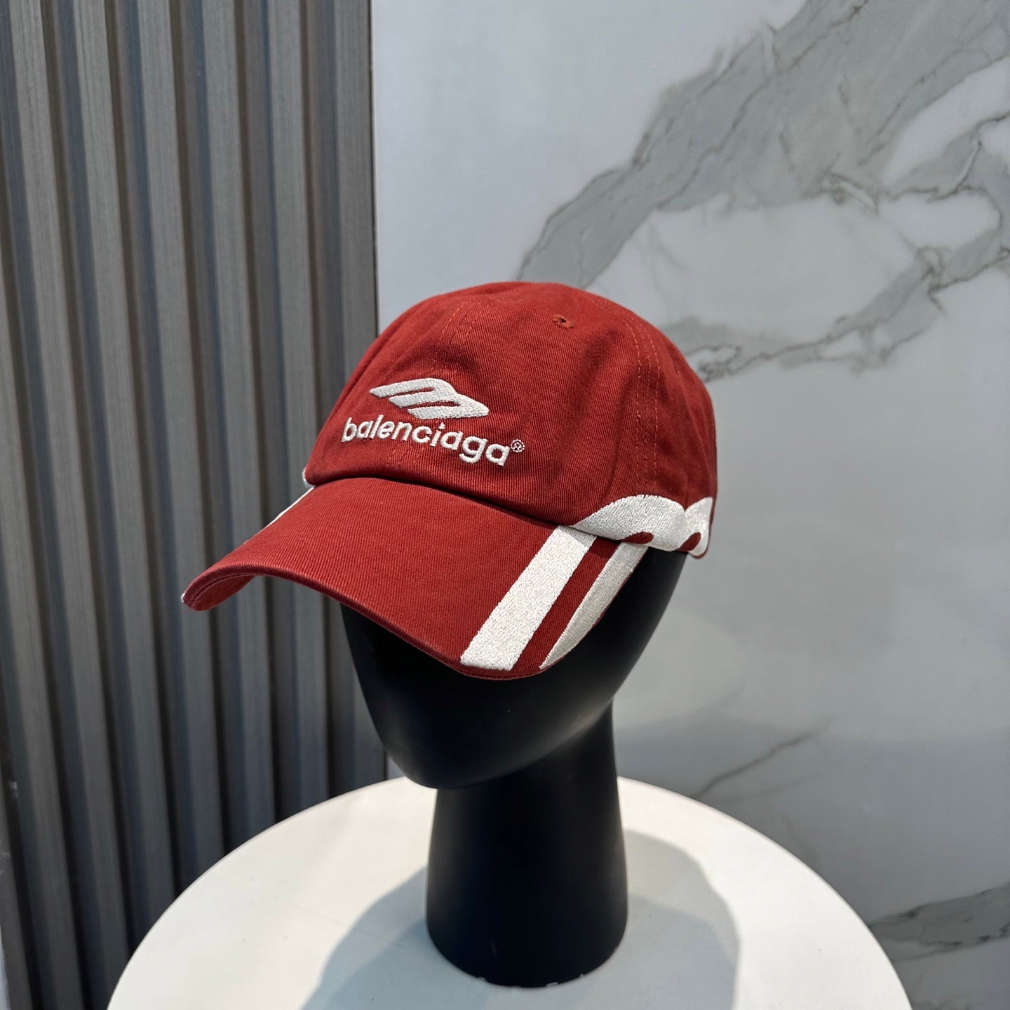 A vibrant red baseball cap featuring bold white side stripes and centered white embroidery.