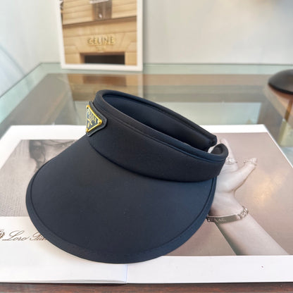 A sleek black wide-brim sun visor featuring a gold triangular emblem, designed for sun protection.