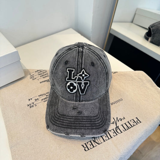 Distressed charcoal denim baseball cap with an embroidered LOVE patch featuring flower accents.