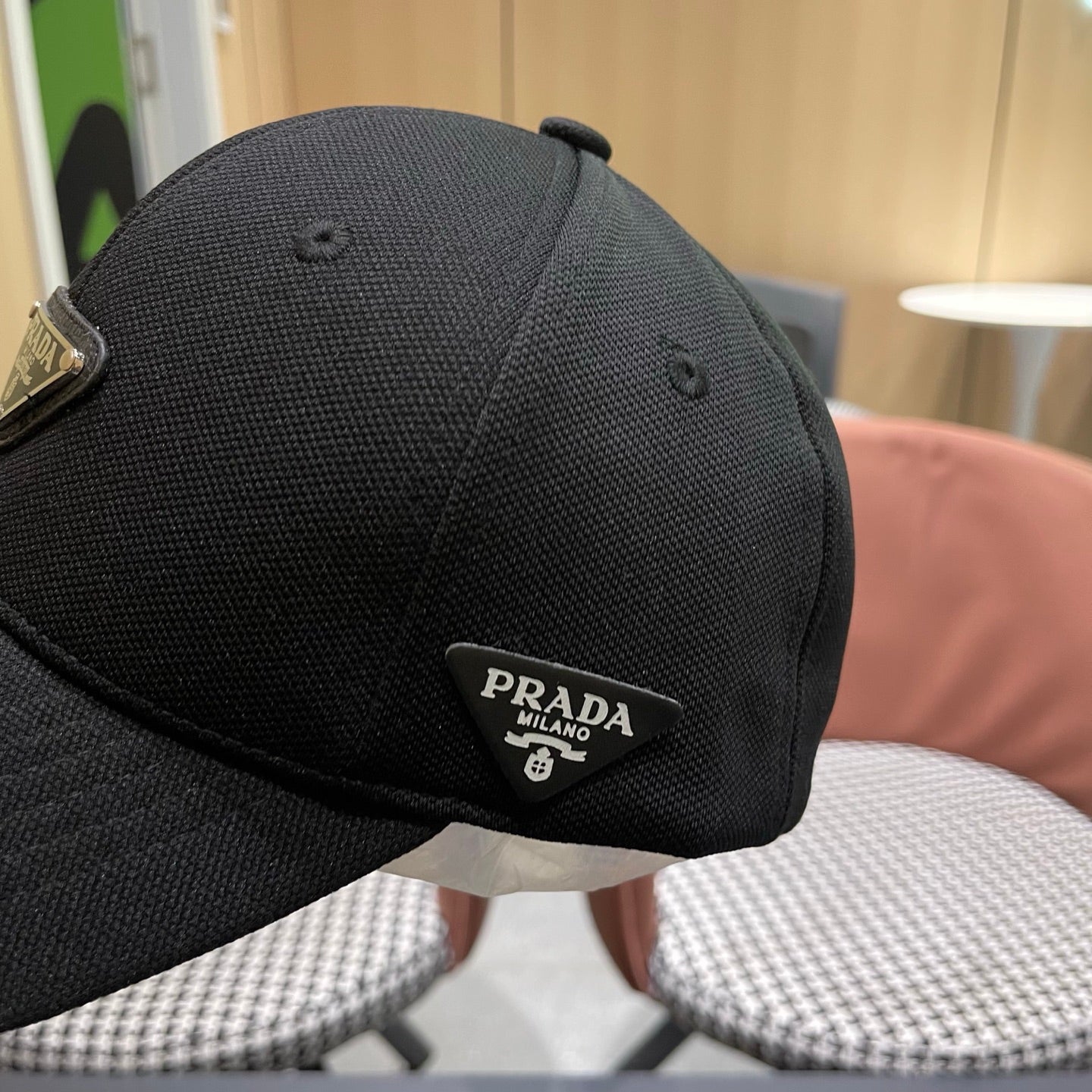 A black premium structured baseball cap with a centered metal triangular emblem on the front.