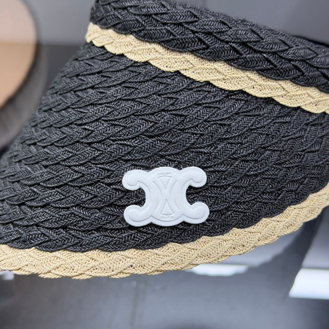 Close-up of a stylish woven straw sun visor with contrast border and white emblem detail.